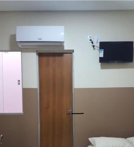 Pokój z drzwiami i telewizorem na ścianie w obiekcie Center Prime Hotel w mieście Bom Jesus da Lapa