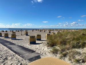 Burgtiefe auf Fehmarn にあるFewo-Strandnixeの海を背景に椅子が置かれたビーチ