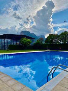 a large blue swimming pool with mountains in the background at Càmping Organyà Park in Organyà