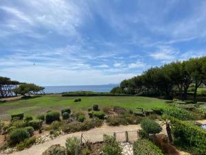 un campo con plantas y árboles y el océano en Sea-View - Wifi - Parking, en Six-Fours-les-Plages