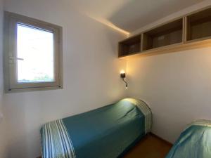 - un canapé vert dans une chambre avec fenêtre dans l'établissement Sea-View - Wifi - Parking, à Six-Fours-les-Plages