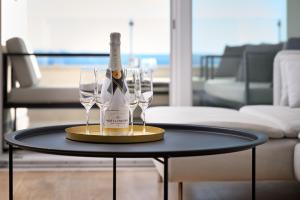 a bottle of champagne and two wine glasses on a table at Klara Beach Apartment in Split