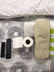 宿霧市的住宿－CHE & JAMES FEMALE GUEST House COLON, CEBU，一张带毛巾和卫生纸的床以及遥控器