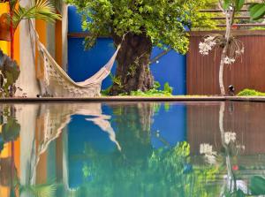 a tree and a hammock next to a swimming pool at Estalagem Bonfim, 351 in Olinda