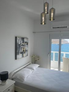 sypialnia z łóżkiem i widokiem na ocean w obiekcie VILLA BLANCA w mieście Charaki