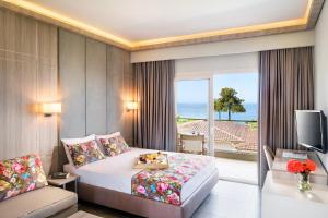 a hotel room with a bed and a balcony at Alexandra Beach Spa Resort in Potos