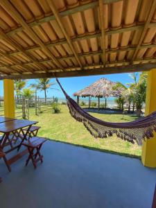 a hammock in a resort with a table and benches at OCA Caraíva in Caraíva