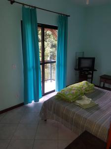 a bedroom with a bed and a sliding glass door at Belissima casa em Itauna a 300 metros da praia in Saquarema +15 photos