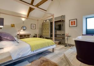 a bedroom with a bed and a tub in it at Tir Bach Iago in Llangwnadl