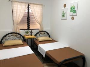 two beds in a room with a window at Hiraya Homestay Coron in Coron