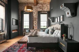 a bedroom with a bed and a couch and a fireplace at The Lincoln Hotel in Biddeford