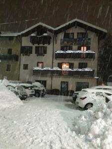 un aparcamiento cubierto de nieve frente a un edificio en Casa Salvaterra Affittacamere en Pinzolo