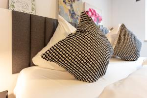 a bed with two black and white pillows on it at Landhotel Gutshof in Hartenstein