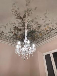 a chandelier hanging from a ceiling with flowers at Affreschi sul mare in Marina di Pisa