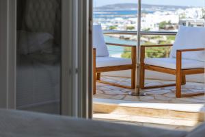 a balcony with two chairs and a view of the city at Paliomylos Spa Hotel in Naousa