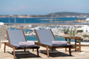 Duas cadeiras sentadas em cima de uma varanda com vista em Paliomylos Spa Hotel em Naousa