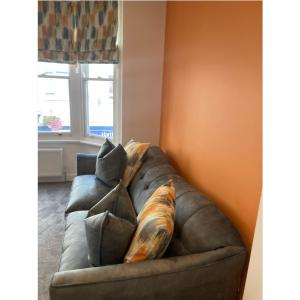 a couch with pillows on it in a living room at Printer's Apartment in Pontefract