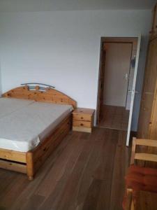 ein Schlafzimmer mit einem Holzbett und einem Eingang in der Unterkunft Homalux 1,5 Zimmer-Yachthafen / Südstrand in Burgtiefe auf Fehmarn 