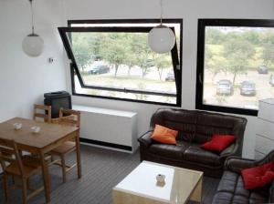 ein Wohnzimmer mit einem Sofa und einem Tisch in der Unterkunft Homalux 1,5 Zimmer-Yachthafen / Südstrand in Burgtiefe auf Fehmarn 