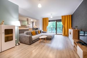 ein großes Wohnzimmer mit einem Sofa und einer Küche in der Unterkunft Tampa Gardens Apartments - Adults Only in Braşov