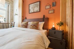- une chambre dotée d'un mur orange avec un lit et une table dans l'établissement São Vitor Studio w/ Patio by LovelyStay, à Porto