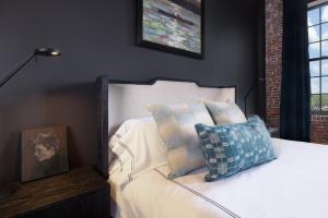 a bedroom with a bed with a pillow on it at The Lincoln Hotel in Biddeford