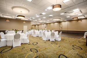 um salão de banquetes com mesas e cadeiras brancas em Holiday Inn Morgantown - Reading Area, an IHG Hotel em New Morgan
