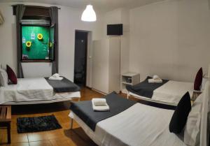 um quarto com três camas e uma janela com uma bola de futebol em Alojamento Local Tamega em Amarante