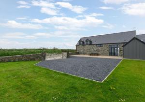 a stone house with a garden and a barn at Llain Iago in Llangwnadl