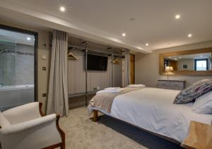 a bedroom with a large white bed and a television at Llain Iago in Llangwnadl