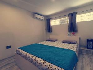 - une chambre avec un lit et une couverture bleue dans l'établissement Lovely two bedrooms apartment., à Flic-en-Flac