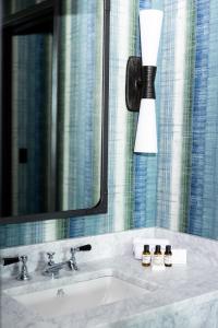 uma casa de banho com um lavatório, um espelho e um candeeiro em The Lincoln Hotel em Biddeford