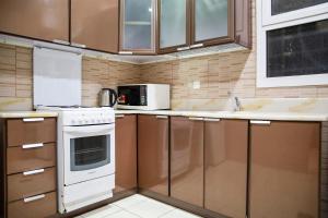 a kitchen with brown cabinets and a white stove top oven at Wasn Suites in Riyadh