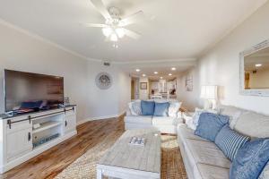 a living room with a couch and a flat screen tv at Turtle Sea Dunes II in Fernandina Beach