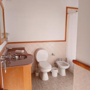 een badkamer met een toilet, een bidet en een wastafel bij Refugio del Arroyo in San Martín de los Andes