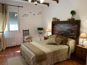 een slaapkamer met een bed en een bakstenen muur bij Torcales del Lobo Apartamentos Rurales in Pozo Alcón