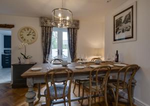 a dining room table with chairs and a clock on the wall at Dau Ddeg Tri in Conwy