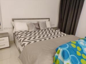 a bedroom with a large bed with white and gray pillows at Hawana Salalah Laguna Studio in Salalah