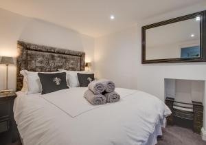 a bedroom with a white bed with towels on it at Dau Ddeg Tri in Conwy