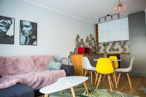 a living room with a couch and a table and chairs at YamaLux Apartments - HappyApartment - close to IuliusMall in Cluj-Napoca