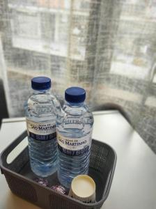 duas garrafas de água sentadas num cesto sobre uma mesa em Alojamento Local Tamega em Amarante