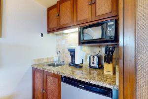 a kitchen with a sink and a microwave at Islander on the Beach 333 in Kapaa