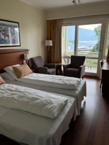 ローセンダールにあるRosendal Fjordhotelのベッド2台と大きな窓が備わるホテルルームです。