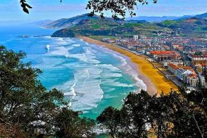 a view of a beach with a city and the ocean at Azaraleku apartamento playa in Zarautz