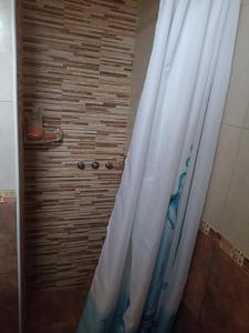 a shower with a white shower curtain in a bathroom at San Jorge in Tres Arroyos