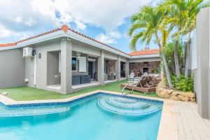 a villa with a swimming pool and a house at Casa Karlina in Palm-Eagle Beach