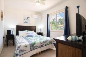 a bedroom with a bed and a tv and a window at Casa Karlina in Palm-Eagle Beach +17 photos
