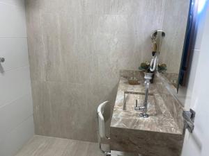 uma casa de banho com um lavatório em mármore e um chuveiro em Antonio's Hotel e Spa - Airport em Brasília