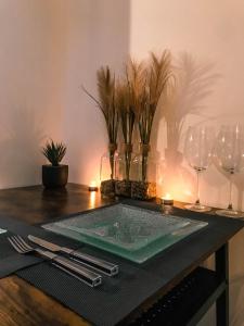 - une table avec des verres à vin et une assiette verte dans l'établissement The Golden Bridge - Appartement Confort - Centre-Ville, à Abbeville
