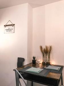 a dining room table with two chairs and a wine glass at The Golden Bridge - Appartement Confort - Centre-Ville in Abbeville